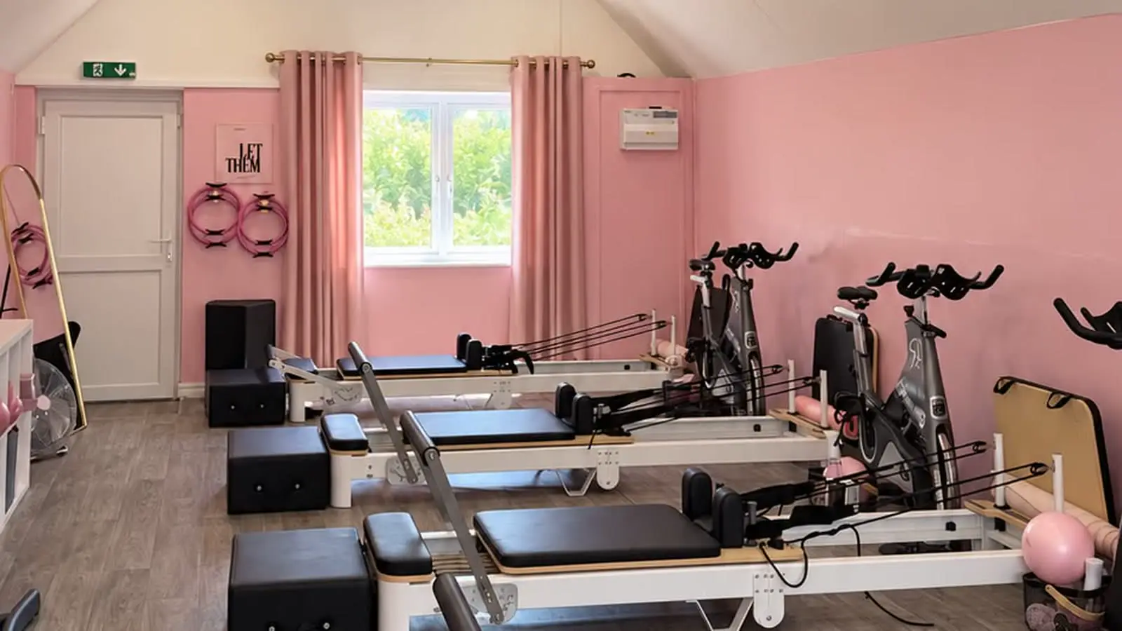Fabulook Fitness UK studio in Arrington: pink walls, reformer beds and spin bikes looking toward the window